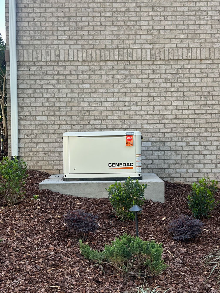 Tankless water heater and electrical conduits mounted on a brick exterior wall with exposed wiring.